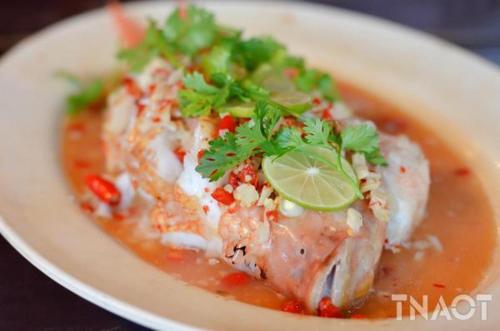a bowl of soup with a piece of fish with a lime at Sweet Time Bungalows in Koh Rong Sanloem