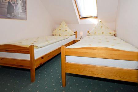 two twin beds in a room withthritisthritisthritisthritisthritisthritisthritisthritisthritis at Ferienwohnungen im Huus Janssand in Bensersiel