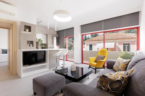 een woonkamer met een bank en een tv bij A Luxury Retreat in Corfu Town by Konnect in Corfu-stad