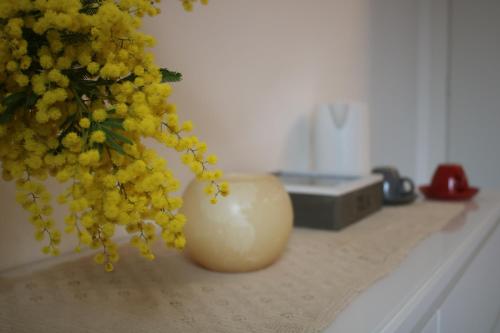 a vase filled with yellow flowers sitting on a counter at Al GrattacieloTrenta in Verona