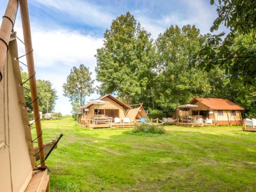 a group of tents in a field with trees at Lodge Holidays - Vrijhaven Heeg in Heeg