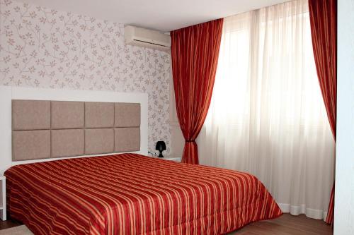 um quarto com uma cama vermelha e uma janela em Sofia hotel apartments em Sófia