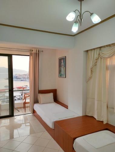 a bedroom with a bed and a balcony at Olympia Hotel in Sarandë