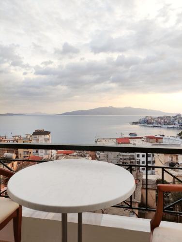a table on a balcony with a view of the water at Olympia Hotel in Sarandë