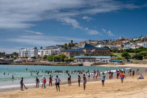 a large group of people on a beach at 7 Diaz in Mossel Bay