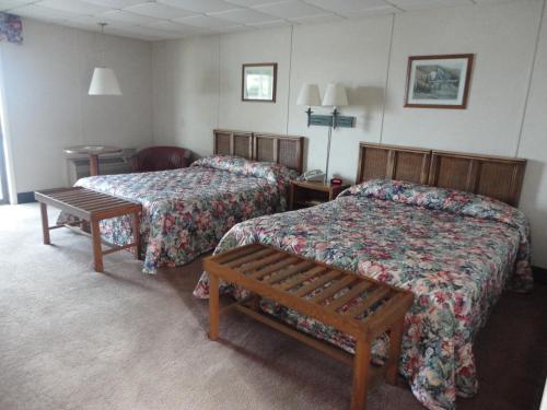 a hotel room with two beds and a bench at Island Resort in Chincoteague