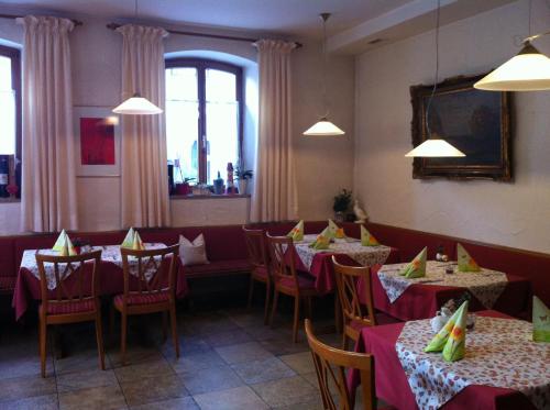 a dining room with tables and chairs with red table cloth at Genießerhotel Limbacher in Herrieden