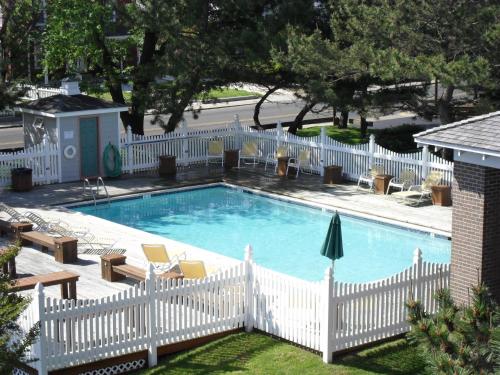 a swimming pool with a white picket fence and a white picket at Island Resort in Chincoteague