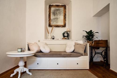 a bench with pillows and a table in a room at Schlaf.Cabinet im Bio.Weingut (Lesehof seit 1424) in Krems an der Donau