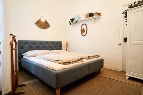 a bedroom with a bed with a blue headboard at Schlaf.Cabinet im Bio.Weingut (Lesehof seit 1424) in Krems an der Donau