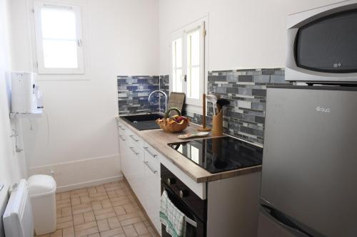 eine Küche mit einer Spüle und einem Kühlschrank in der Unterkunft La Belle Onde in Dieppe