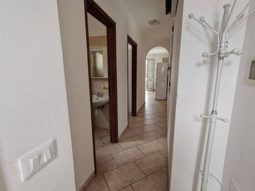 un corridoio con bagno con lavandino e specchio di Appartamento De Gama a Torre Pali
