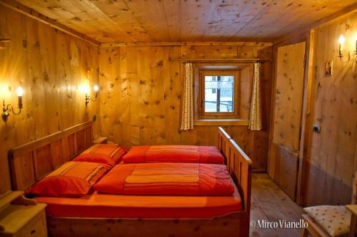 sypialnia z łóżkiem w drewnianym pokoju w obiekcie Bed & Breakfast Campaciol w Livigno