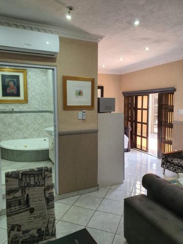 a room with a kitchen and a living room at Romans Rest Guest House in Carletonville