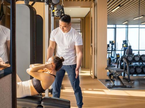 a man standing next to a woman in a gym at Pullman Dali in Dali