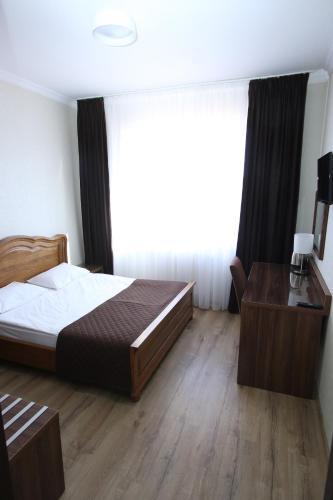 a bedroom with a bed and a desk and a window at BAYKA - SPA resort in Kosiv