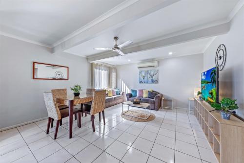a living room with a table and a couch at Airlie Apartments in Airlie Beach