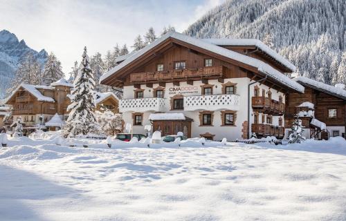 a ski lodge in the snow with snow covered at Cima Dodici B&B - Apartments in Sesto
