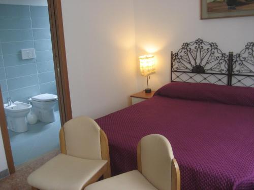ヴェローナにあるB&B Samuelのベッドルーム1室(ベッド1台、椅子2脚、トイレ付)