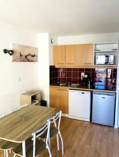 - une cuisine avec une table en bois dans une chambre dans l'établissement Les Terrasses, à Cayeux-sur-Mer