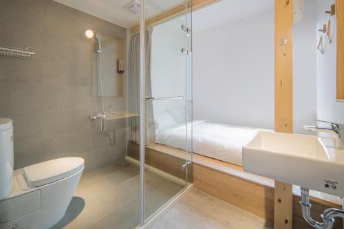 a bathroom with a shower and a toilet and a sink at 山鄰山林青年文旅 forest 3030 hostel in Yuli