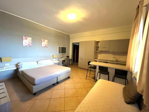 a hotel room with a bed and a kitchen at Kalaskiso' in Giardini Naxos