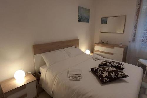 um quarto com uma cama branca com 2 candeeiros em Appartamento a due passi da Piazza del Campo em Siena
