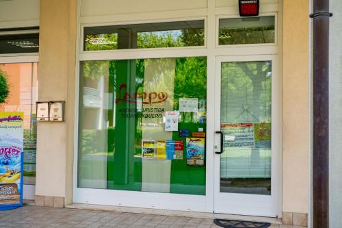 a door to a store with signs in it at Pini Village Lido Altanea in Caorle