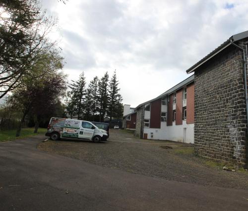 a white van parked next to a brick building at Gîte Familial et Rural in Vernines