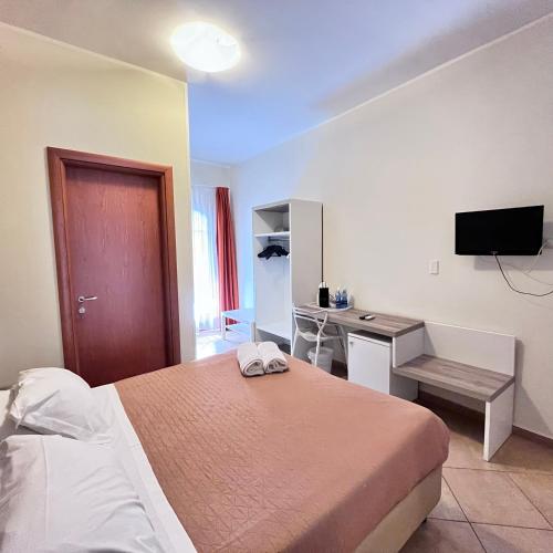 a bedroom with a bed and a desk and a television at Kalaskiso' in Giardini Naxos