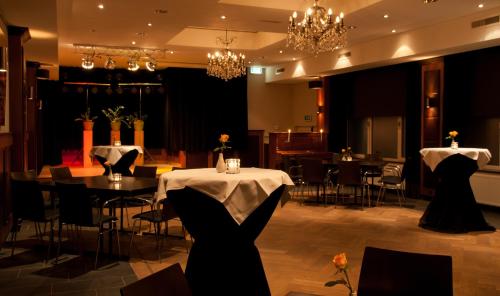 a banquet hall with tables and chairs and chandeliers at Hotel Restaurant St. Lambert in Helmond