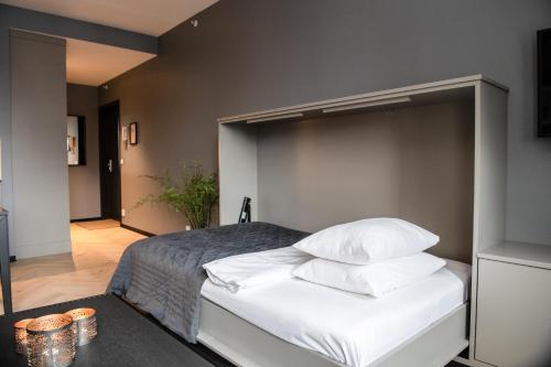 a bedroom with a bed with white sheets and pillows at Origo Leilighetshotell in Drammen