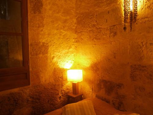 a lamp sitting next to a bed in a room at La Tour Beauvoir in Blois