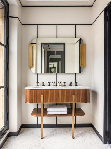 une salle de bain avec un lavabo et un miroir dans l'établissement Pavillon Faubourg Saint-Germain & Spa, à Paris