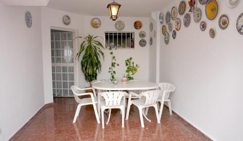 een eetkamer met een witte tafel en stoelen bij Casa Soleada en Calle Tranquila in Sevilla