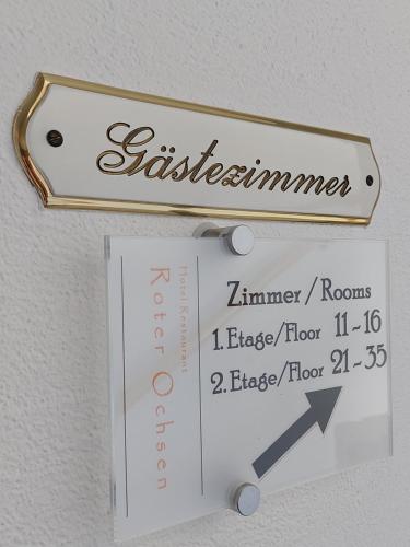 a sign hanging on a wall with a thermometer at Hotel-Restaurant Roter Ochsen in Lauchheim