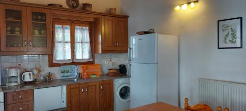 a kitchen with a white refrigerator and a washer and dryer at Sipsas Villas in Koroni