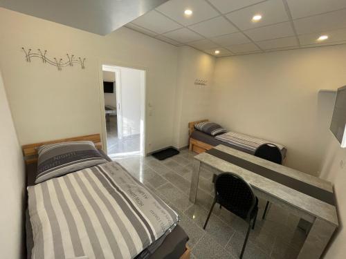 a room with two beds and a table and chairs at Ferienwohnung Osnabrück- Schinkel in Osnabrück