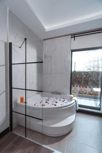 a white bathroom with a tub and a window at Melanj Airport Hotel in Arnavutköy