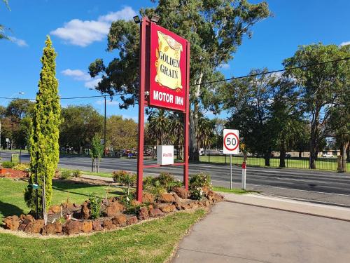 a sign for a hotel on the side of a road at Golden Grain Motor Inn in Horsham