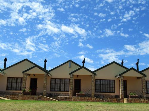 a row of houses with a blue sky in the background at Mountain Pastures Game Lodge in Uniondale