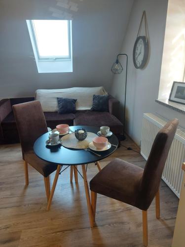 een woonkamer met een tafel en stoelen en een bank bij Apartament Kala in Nysa