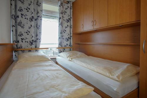 2 camas en una habitación con ventana en Haus-Belvedere-Wohnung-75-Silbermoewe, en Großenbrode