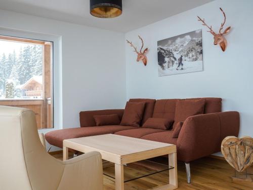 a living room with a couch and a table at Kitzbühel alpine lodge with private infrared sauna in Mittersill