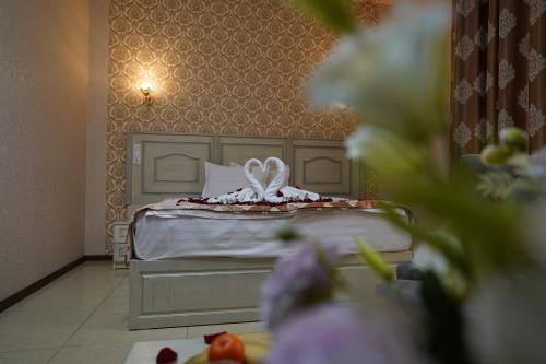 a bedroom with a bed with a white pillow at Sofiya Tashkent Hotel in Tashkent