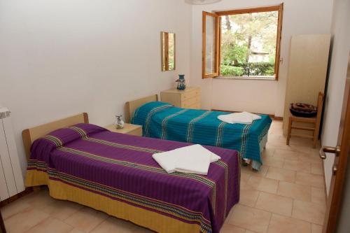 a room with two beds and a window at Elena Residence in Torchiara