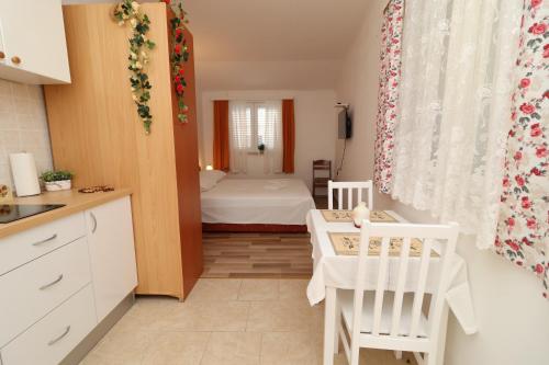 a small kitchen with a bedroom with a bed at Apartments Sergej in Drače