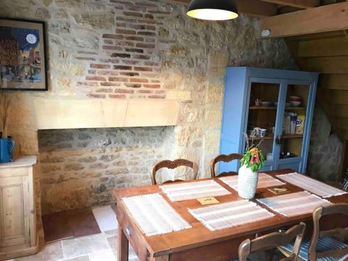 une table en bois avec des chaises et un meuble bleu dans l'établissement La Maison du Puit (the house with the well), à Castels