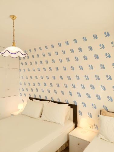 a bedroom with blue flowers on the wall at Olympia Hotel in Sarandë