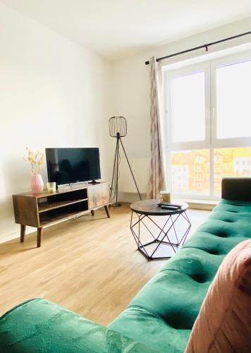 uma sala de estar com um sofá e uma televisão em Gemütliches Studio - Elias- mit Küche, WLAN, Smart-TV & Panoramablick in Citynähe em Erfurt
